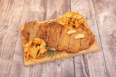 Jambonlu ve peynirli sığır eti, un, yumurta ve ekmek kırıntıları ve ev yapımı cips ile süslenmiş patates.