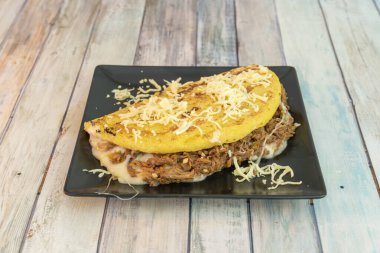 Erimiş peynirle dolu mısır cachapa ve üstünde bir top tereyağı. Venezuela yemekleri