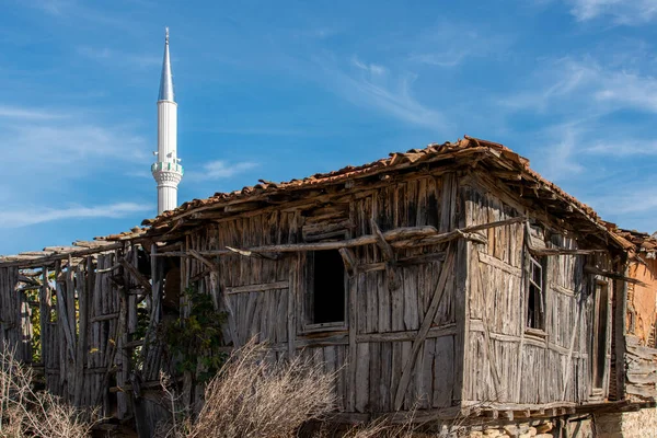 トルコのどこかの後ろにヴィンテージ未処理の木の小屋とモスクのミナレット — ストック写真