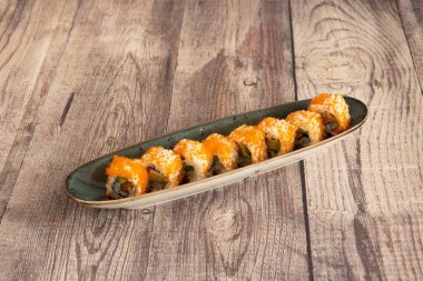 Balık yumurtası ve somon ve avokado ile doldurulmuş yosun dolu uramaki California tepsisi.