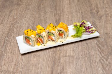 Norveç somonu uramaki suşi, olgun avokado, nori yosunu, Philadelphia peyniri ve mango parçaları.