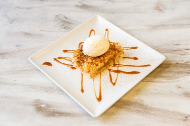 Elmalı turta, karamel şurubu, doğranmış badem ve vanilyalı dondurma.