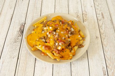 Lezzetli tex meksika patates cipsi tarifi baharatlı acı biber yahnisi, pico de gallo ve bolca erimiş çedar peyniri.