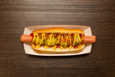 Turşulu sosisli, pişmiş sosis, ketçap, hardal ve karton tepside kızarmış soğan.