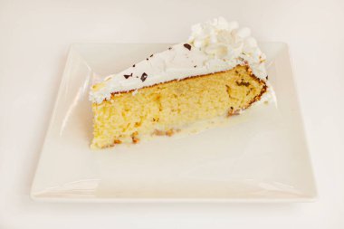 Süngerli limonlu kek, krema ve beyaz çikolata şurubu.