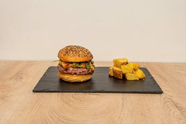 Klasik roka, çedar peyniri, soğan, ketçap, hardal ve yanında patates kızartması.