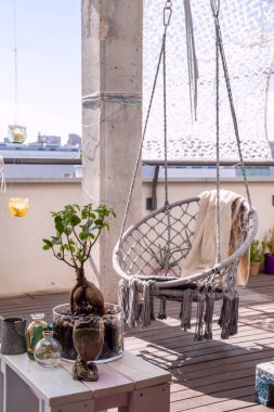 Balili hamak, ahşap döşemeler ve dekoratif bitkiler.