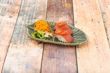 Japon pilavı nigiri sushi, üstünde kırmızı ton balığı ve vişneli domates olsun.