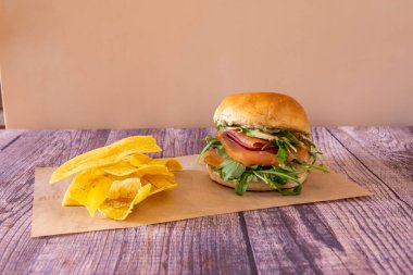 Brioche ekmekli balık burger füme somon, roka, olgun avokado, dereotlu salsa ve kızarmış muz cipsi.