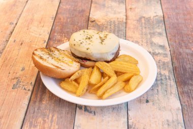 Erimiş keçi peynirli sade dana burger, kekik, zeytinyağı ve patates kızartması.