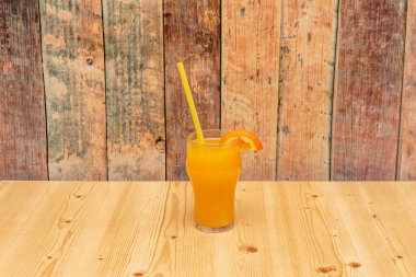 Saman ve taze sıkılmış portakal suyunun kenarında dilimlenmiş kristal cam.