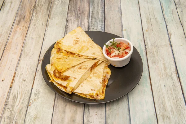 Meksika usulü senkronize quesadilla hindiba güveci ve eritilmiş peynirle doldurulmuş bir kap pico de gallo