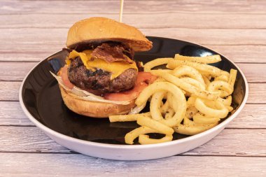 Çedar peynirli sığır burger, kızarmış İber jambonu, Domates ve sarımsaklı patates kızartması.