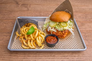 Marullu tavuk burger, Brioche ekmekli turşu, limon dilimi, barbekü sosu ve patates kızartması.