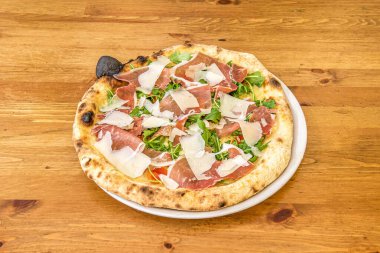 Fındıklı İtalyan Arugula Pizzası, Parmesan Peyniri Dilimleri ve Domates ve Mozzarella ile Prosciutto.