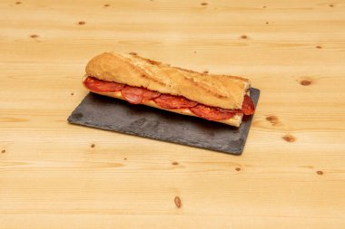 Geleneksel İspanyol sucuklu sandviçi ahşap masada.