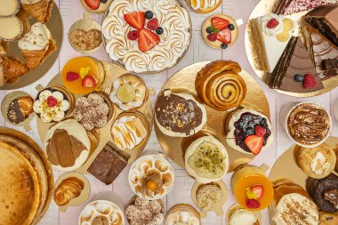 Dulce de leche şehvet düşkünü pastayı sünger keki arasında cömert katmanlarla süsleyip altın kremayla süslüyor.