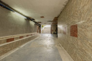 Garaj tarzı garaj, Iroko ahşap sütunları ve peyzajlı çatısı var, peyzajla bütünleşmiş.