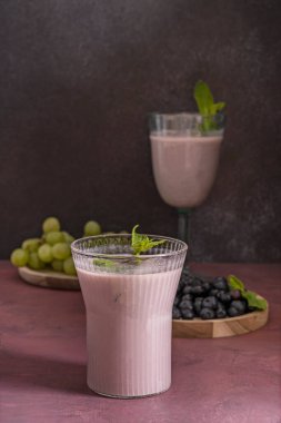 Taze toplanmış organik yaban mersini ve kayın ağacının üzerinde görülebilir düğümlü kremalı köpüklü yaban mersini smoothie.
