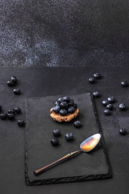 Siyah kadife arka planda yaban mersinli bir hayat ve kompozisyona zarafet katan klasik bir kaplumbağa kabuğu kaşığı.