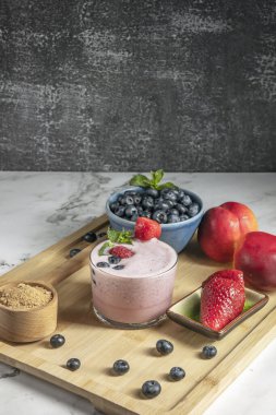 Koyu renkli yaban mersini ve yaban mersini ve kiraz ağacından yapılmış bir masada baobab smoothie.