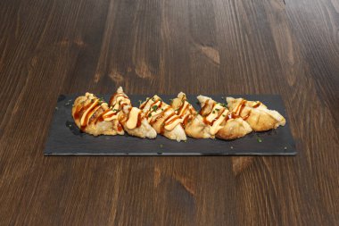 Kızarmış hamur köfteleri yaban mantarı, pırasa ve havuçla doldurulmuş soya sosu ve daldırmak için neşe katılmış.