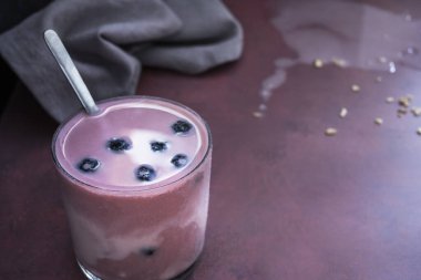  Doğal bir bambu tahtası üzerinde parlak yaban mersini ve yaban mersini ve chia smoothie yakın çekim
