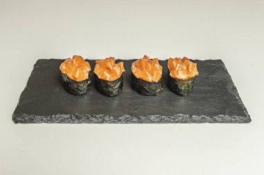 Krem peynirli ve salatalıklı füme alabalık, ince dilimlenmiş salatalık ve porselen.