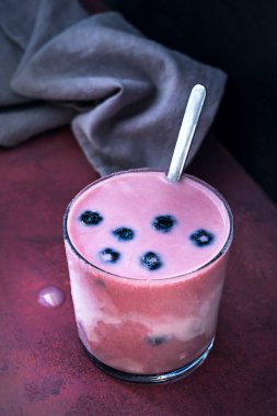 Yaban mersini ve yabanmersinli smoothie. Açık meşe ağacından bir masada badem sütü.