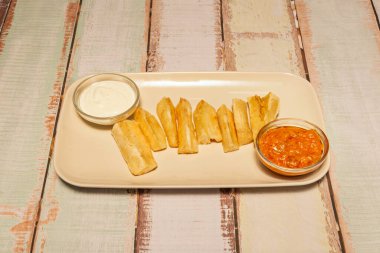 Ev yapımı kızarmış yuca, çıtır çıtır ve yumuşak bir merkez üzerine sarımsak tuzu ve taze doğranmış maydanoz serpiştirilmiş.