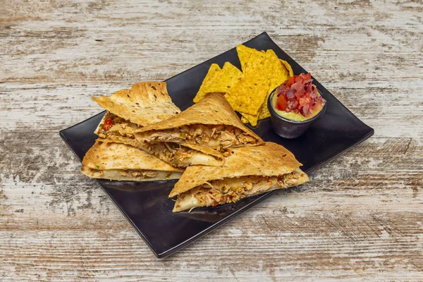 Erimiş Oaxaca peynirli kabak çiçeği quesadillas, doğranmış soğan ve taze yapılmış mavi mısır tortillası üzerine taze epazot.