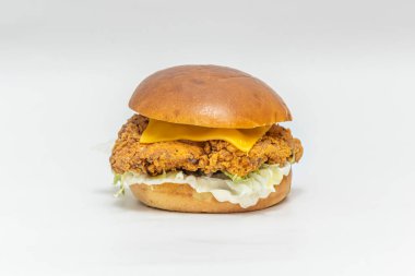 Akdeniz usulü çıtır tavuk burger, beyaz peynir, güneşte kurutulmuş domates, fesleğen sosu ve karışık yeşillik.