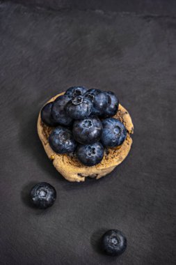 Ön planda tek başına bir yabanmersini kompozisyona hakim olur, siyah arkaplan karanlığa gömülürken bütün detaylarıyla ortaya çıkar.