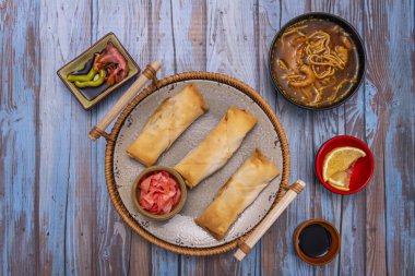 Şeffaf karides böreklerinin bileşimi dolguyu gözler önüne seriyor, mor marul ve aromatik otlarla servis edilen cam bir tabakta servis ediliyor.