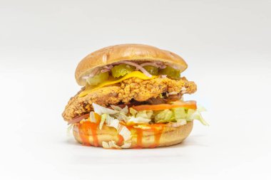 Baharatlı çıtır tavuk burger, bufalo sosu, parçalanmış mavi peynir ve kızarmış sarımsaklı ekmek üzerine taze kereviz.