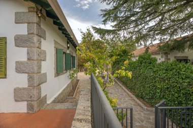 Tek aile evini çevreleyen dış çevre geçidinin mimari fotoğrafı. Gri granit döşeme ve eşleşen granit duvarlar.