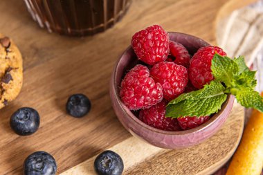 Yarısı kesilmiş yaban mersinleri sulu iç kısımlarını ortaya çıkarır. Bu da hafif ahşabı mor renklerle renklendirmeye başlar..