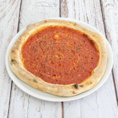 Klasik Margherita pizzası mükemmel basitliğini bir taban domates, taze fesleğen ve çıtır çıtır kremalı burrata ile sergiliyor.