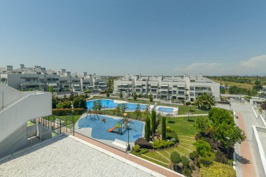 Ayrı bir çocuk havuzuyla aile havuzu kompleksi ve yavaş yavaş derinliği azalan gölgeli ağaçlar ve kaymayan kaldırımlarla dolu bir halk bahçesinde yer alıyor.