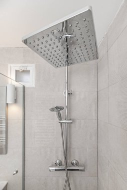 Ekranı olmayan minimalist bir banyo, doğrusal bir atık, ve tavan penceresi boyunca aydınlatma