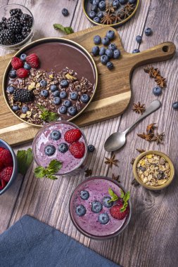 Smoothie 'nin moru, mısır gevreğinin sarısı ve tahtanın kahverengisi arasındaki kromatik kontrast uyumlu bir palet oluşturur.