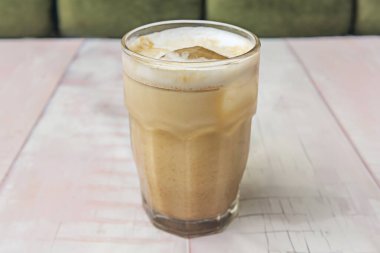 Vanilyalı buzlu latte ile Arabica espresso, badem sütü ve doğal vanilya şurubu, yeniden kullanılabilir bir pipetle servis edilir..