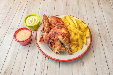 Kızarmış tavuk ve patates püresi yanında çıtır patates cipsi. Beyaz tabakta gurme usulü sunuldu.