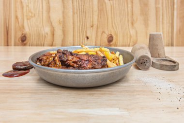 Ekstra çıtır tereyağlı tavuk, patates kızartması ve baharatlı bal, yoğurt ve bitki sosuyla servis edilmiş metal bir sepetin içinde.