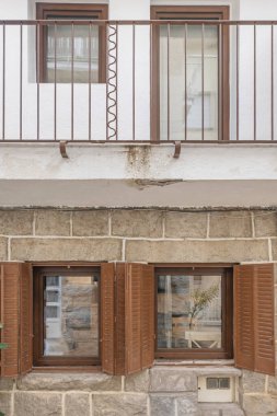 Orijinal gri granitin bölgenin geleneksel inşaat tekniklerine saygı duyarak limon havanıyla birleştirildiği bir ön cephe görüntüsü