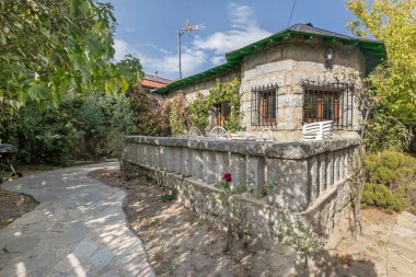 Fotoğraf kompozisyonu, güney cephesindeki yeni iroko ahşap doğramacısıyla doğal yaştaki gri granit arasındaki kontrastı gösteriyor.