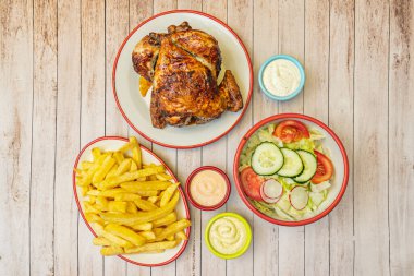 Patatesli kızarmış tavuk, füme paprika, kinoa salatası ve kızarmış limon ile servis ediliyor.