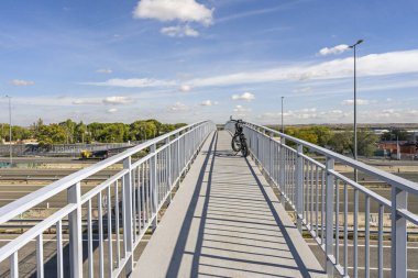 Beyaz metal üst geçidin zarafetini gösteren bir ön görüş otoyol üzerinde hafif bir virajda uzanır.