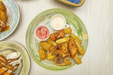 Karayip usulü kızarmış yuca Creole mojo soslu ekşi portakal, sarımsak ve yanında kırmızı soğan turşusu.