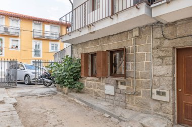 Gri granit bir kamış ve oyulmuş taş köşe taşlarıyla ana cephe, çiftçi evlerinin geleneksel yapı unsurlarını sergiliyor..